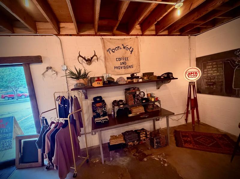 Moon Wolf retail wall — hand-painted banner, antlers, plants, APCO sign, clothing rack Moon Wolf retail wall — hand-painted banner, antlers, plants, APCO sign, clothing rack